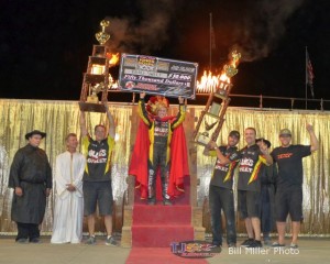 Brad Sweet hoists the $50,000 check while his team holds the trophies after winning the 2013 edition of the Kings Royal. - Bill Miller Photo