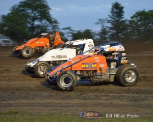 Robert Ballou, Gary Taylor, and Thomas Messeraull racing three wide during the feature at Gas City I-69 Speedway. - Bill Miller Photo