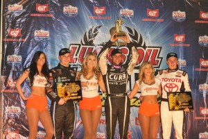 Bryan Clauson lifts the golden driller in victory lane after winning the Chili Bowl Nationals.  second place Kevin Swindell and second place and third place Christopher Bell also on the podium. - James McDonald / Apexone photo