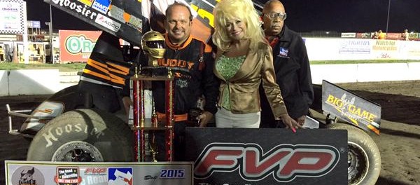Danny Lasoski poses in Victory Lane with "Sandy is Dolly" and flagman Doug Clark Thursday at I-80 Speedway