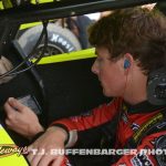 Bryce Lucius watching cars qualify on his phone before going out for his own qualifying effort Friday at Eldora Speedway. (T.J. Buffenbarger Photo)