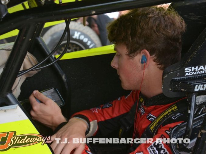 Bryce Lucius watching cars qualify on his phone before going out for his own qualifying effort Friday at Eldora Speedway. (T.J. Buffenbarger Photo)
